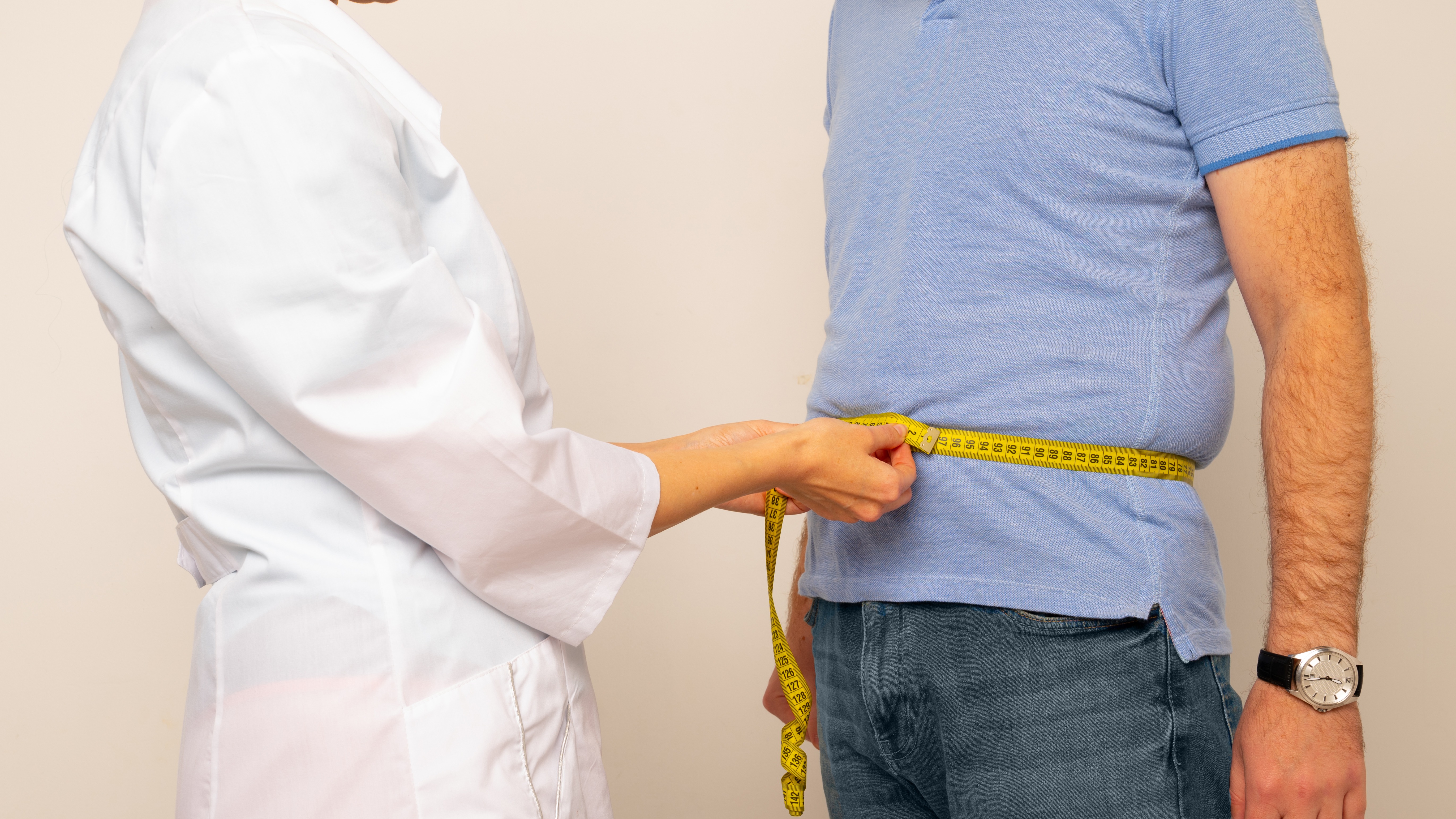 86590962_nutritionist_measuring_overweight_man_s_waist_with_tape.jpg